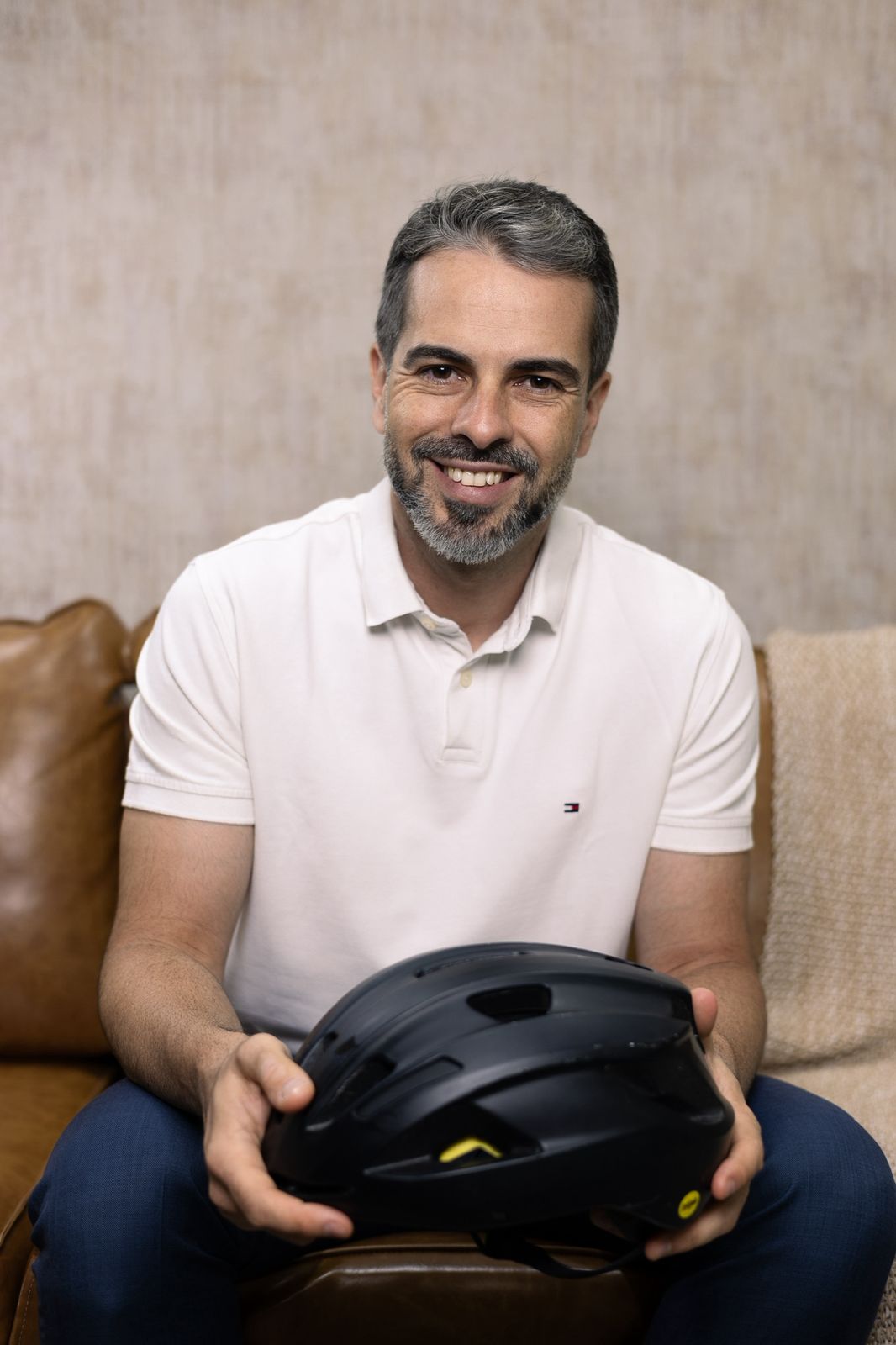 Alexandre Coquet de Abreu de pé, terno azul, ambiente com estante
